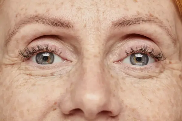 Close up of sparkling blue eyes of young woman with freckles, copy space